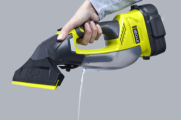 Hand holding RYOBI window cleaner, emptying the water tank.