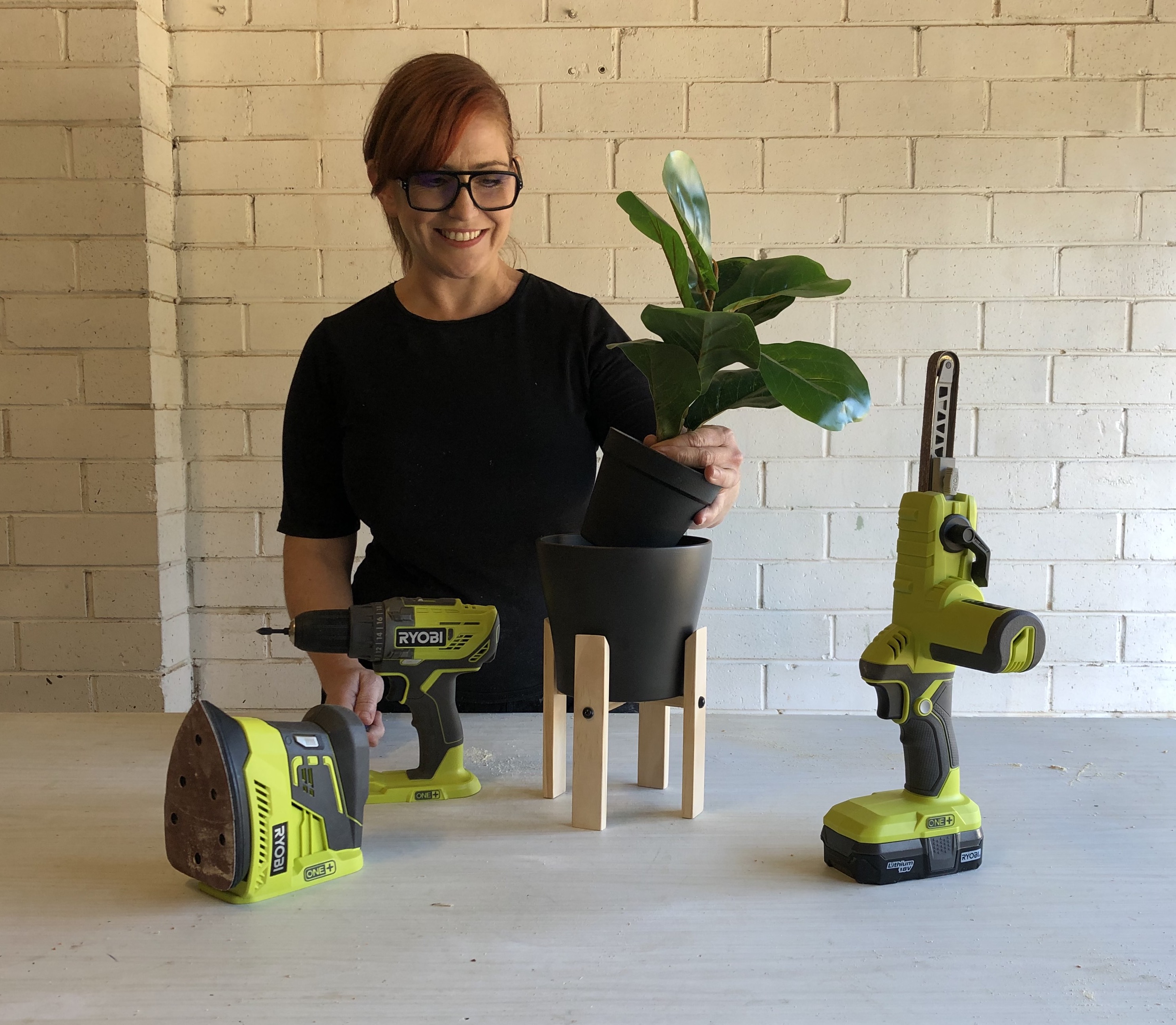 Natasha putting a plant in her newly constructed plantstand