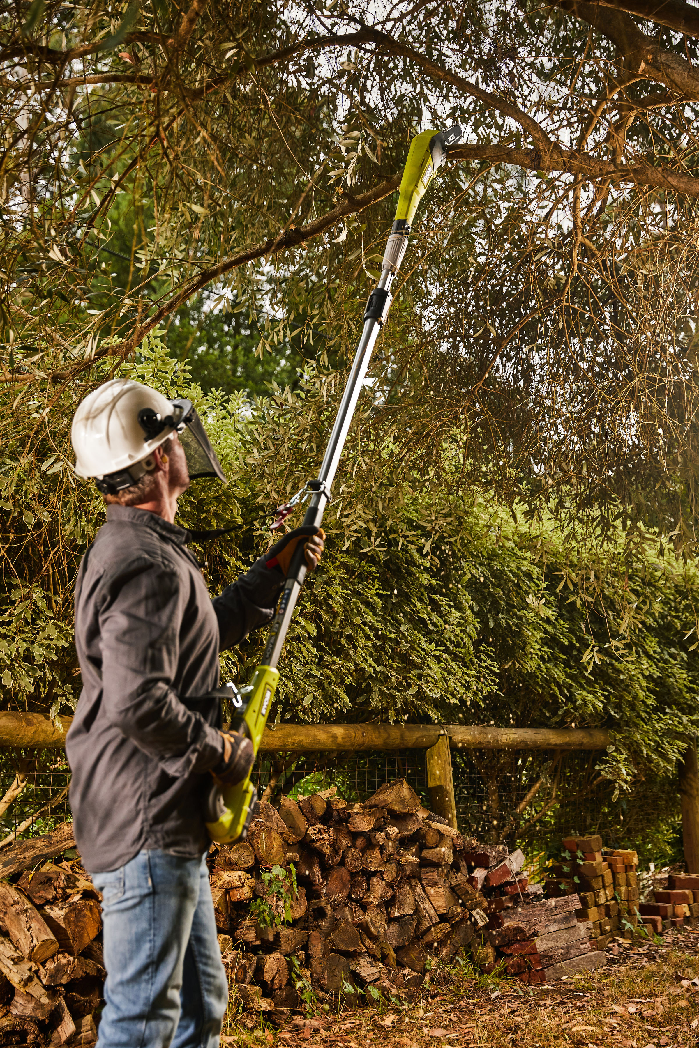 A man uses R18PPSA20 pole pruner