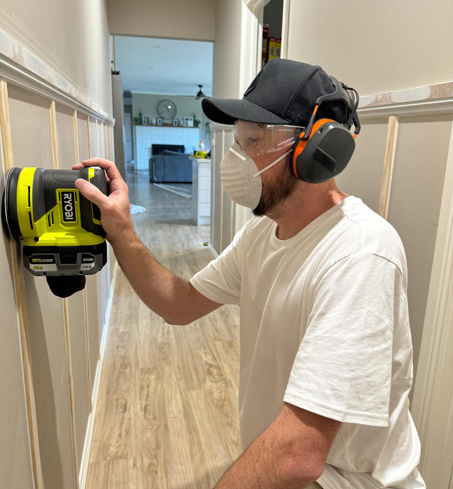 Using a RYOBI Sander to smooth wooden panels