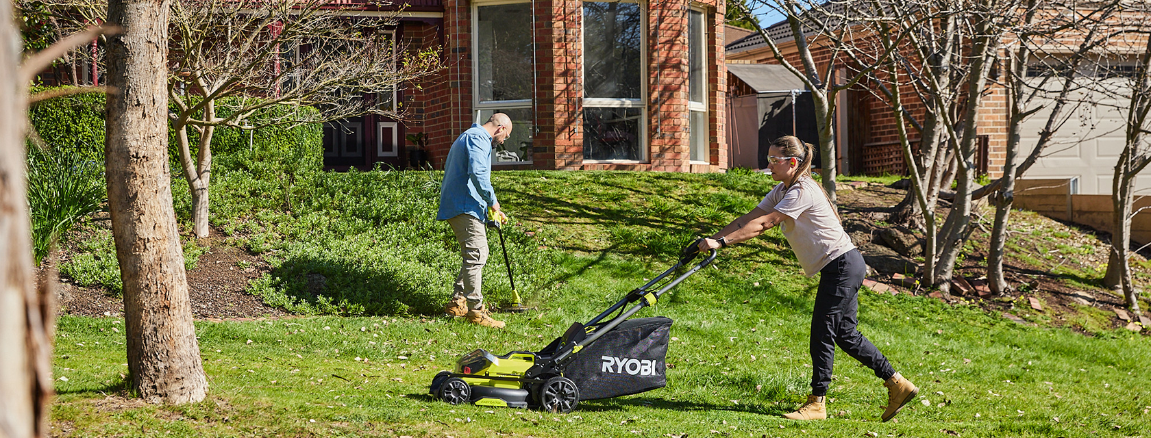 A couple using their Ryobi products in the front garden