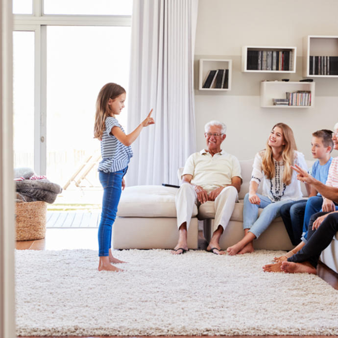 A family gathered in the living room playing charades